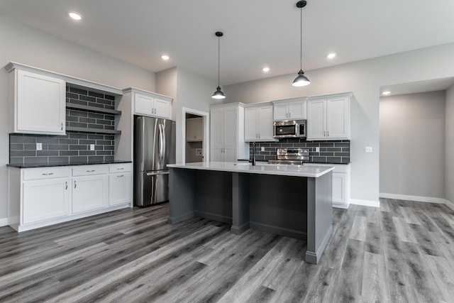 15070 Ada Dr, Hallsville, MO 65255 - kitchen featuring light wood-style floors, tasteful backsplash, stainless steel appliances, and white cabinets