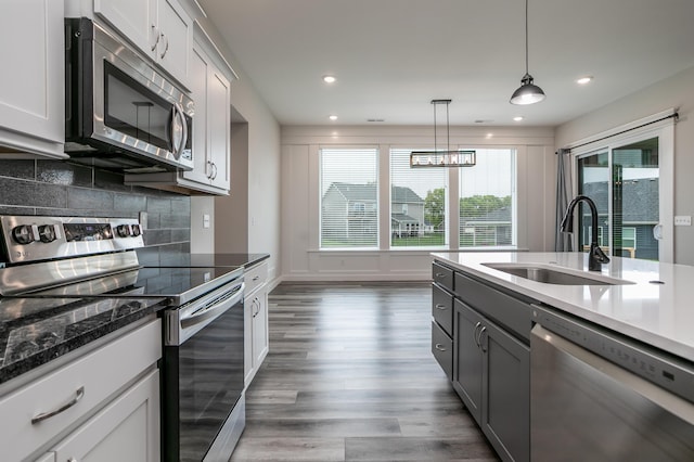 15070 Ada Dr, Hallsville, MO 65255 - kitchen with wood finished floors, tasteful backsplash, a sink, gray cabinetry, and stainless steel appliances
