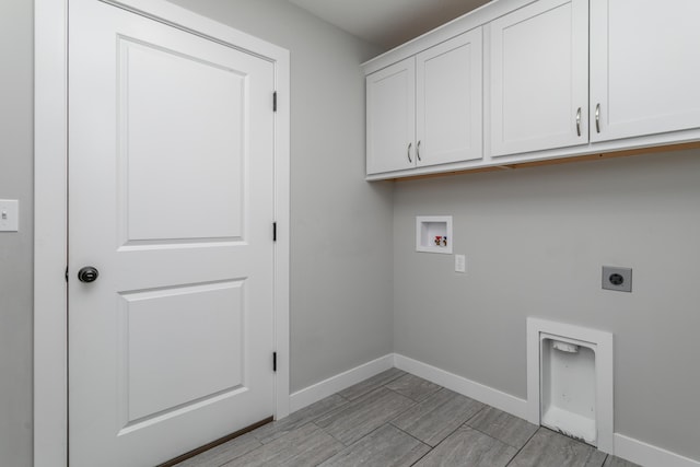 15070 Ada Dr, Hallsville, MO 65255 - clothes washing area with wood tiled floor, electric dryer hookup, cabinet space, baseboards, and hookup for a washing machine