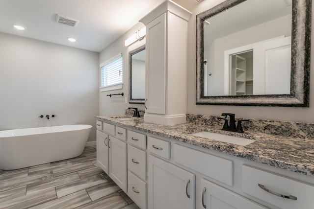 15070 Ada Dr, Hallsville, MO 65255 - bathroom featuring double vanity, visible vents, a sink, and a freestanding bath