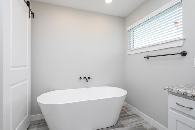 15070 Ada Dr, Hallsville, MO 65255 - full bathroom featuring vanity, wood finished floors, baseboards, recessed lighting, and a freestanding bath