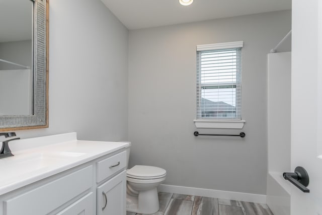 15070 Ada Dr, Hallsville, MO 65255 - full bathroom featuring vanity, wood finished floors, toilet, baseboards, and walk in shower