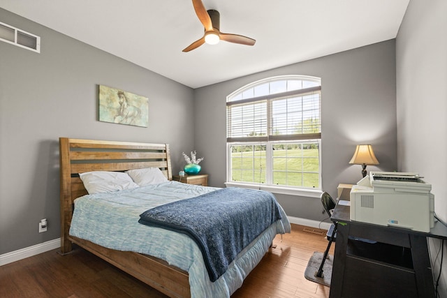 bedroom with baseboards, ceiling fan, wood finished floors, and visible vents