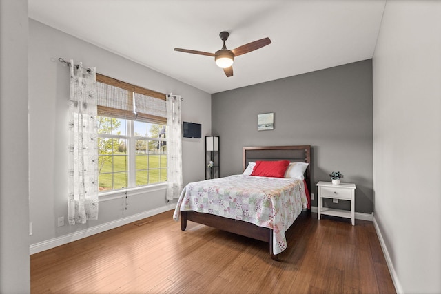 bedroom with baseboards, ceiling fan, and wood finished floors