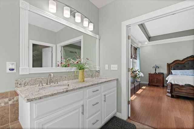 bathroom featuring a sink, ornamental molding, ensuite bath, and double vanity