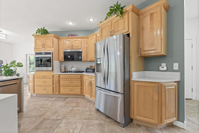 kitchen featuring recessed lighting, light countertops, light brown cabinetry, and stainless steel appliances