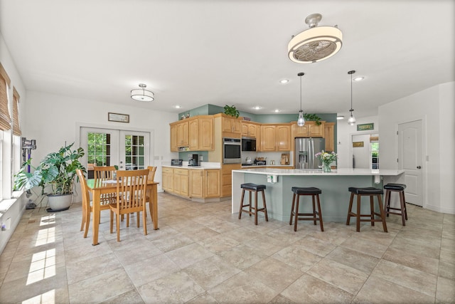 kitchen featuring appliances with stainless steel finishes, light countertops, a breakfast bar area, recessed lighting, and a spacious island