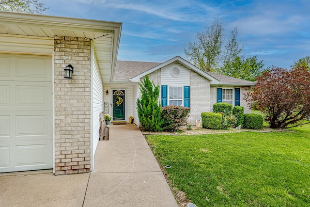 view of front of house featuring brick siding, a shingled roof, a front yard, and a garage