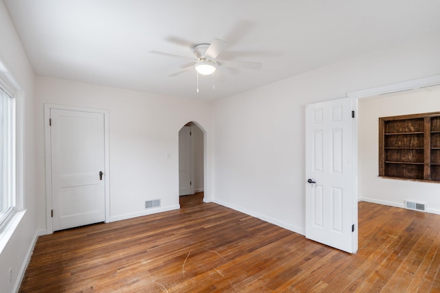 910 Kemper St, Boonville, MO 65233 - spare room featuring arched walkways, wood finished floors, a ceiling fan, and baseboards