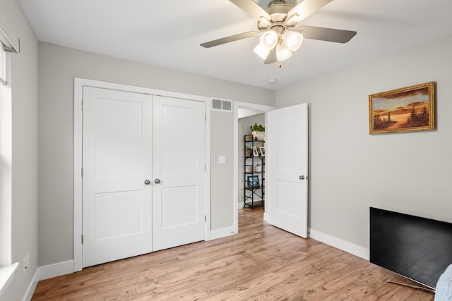 unfurnished bedroom with baseboards, a closet, light wood finished floors, and visible vents
