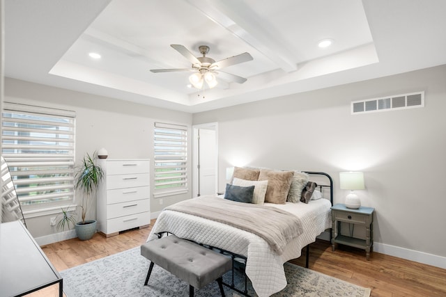 bedroom with baseboards, multiple windows, light wood-type flooring, and visible vents