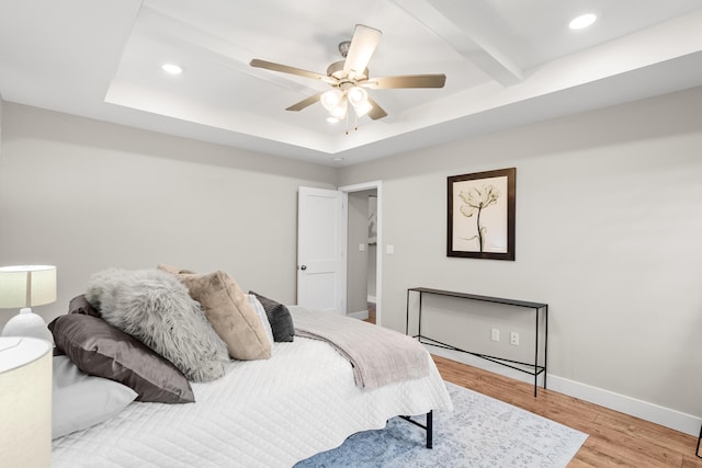 bedroom with ceiling fan, wood finished floors, baseboards, a tray ceiling, and recessed lighting