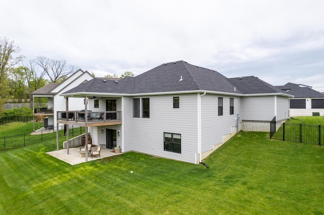 rear view of house featuring a lawn, a ceiling fan, a fenced backyard, and a patio area