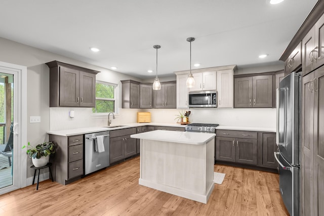 kitchen featuring light wood-type flooring, a sink, appliances with stainless steel finishes, and light countertops