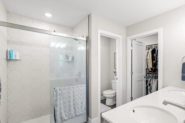 bathroom with a sink, double vanity, toilet, recessed lighting, and a stall shower