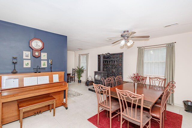 3005 Meghann Dr, Columbia, MO 65203 - dining area with light tile patterned flooring, ceiling fan, visible vents, and a wood stove