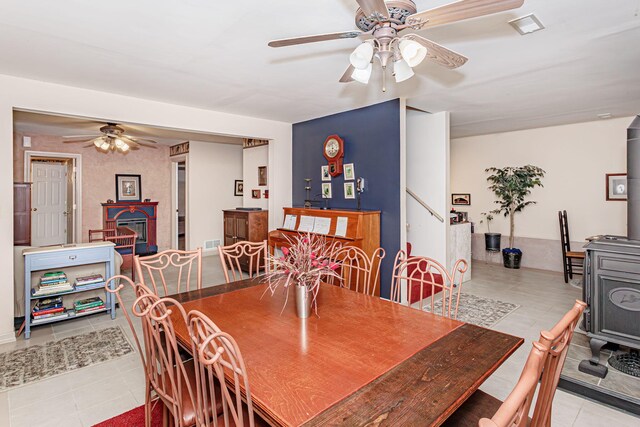 3005 Meghann Dr, Columbia, MO 65203 - dining area featuring tile patterned flooring, a wood stove, a ceiling fan, visible vents, and stairway
