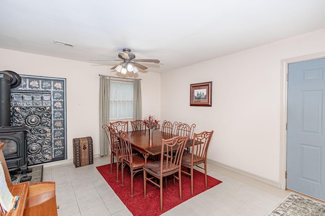 3005 Meghann Dr, Columbia, MO 65203 - dining area with a ceiling fan, visible vents, a wood stove, baseboards, and light tile patterned flooring
