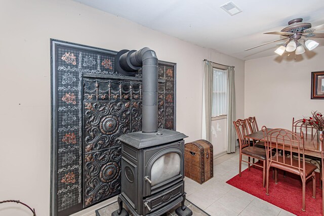 3005 Meghann Dr, Columbia, MO 65203 - tiled dining space with ceiling fan, a wood stove, and visible vents