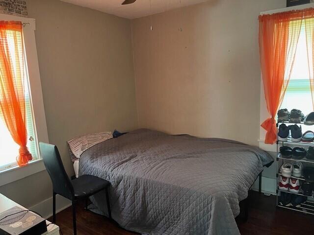 bedroom with wood finished floors and multiple windows