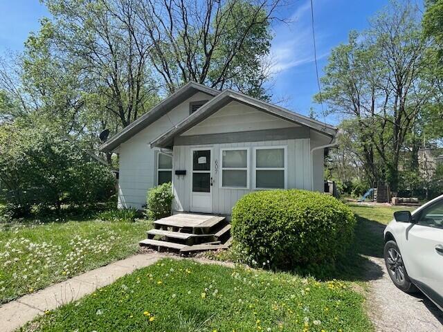view of front facade featuring board and batten siding and a front yard