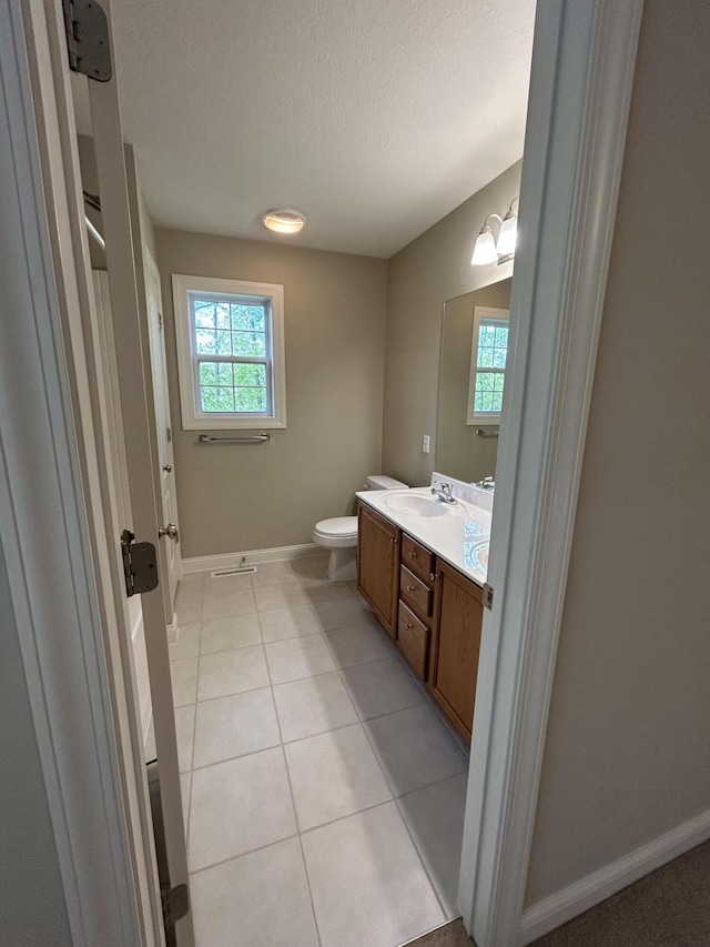 4405 Ferndale Dr, Columbia, MO 65202 - bathroom with a healthy amount of sunlight, baseboards, toilet, and a textured ceiling