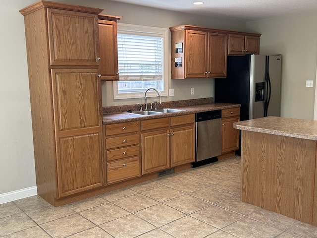 4405 Ferndale Dr, Columbia, MO 65202 - kitchen with stainless steel dishwasher, recessed lighting, brown cabinets, fridge with ice dispenser, and a sink