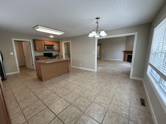 4405 Ferndale Dr, Columbia, MO 65202 - kitchen featuring visible vents, a kitchen island, baseboards, plenty of natural light, and appliances with stainless steel finishes