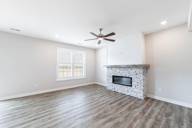 unfurnished living room featuring a fireplace, baseboards, a ceiling fan, and wood finished floors