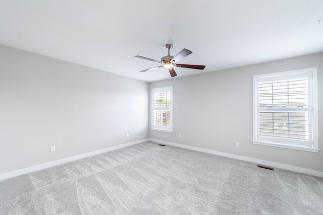 unfurnished room with carpet flooring, baseboards, a ceiling fan, and visible vents