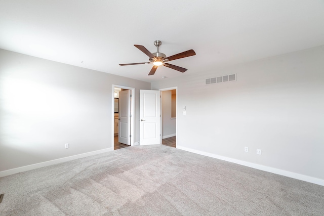 unfurnished room featuring carpet flooring, visible vents, baseboards, and ceiling fan
