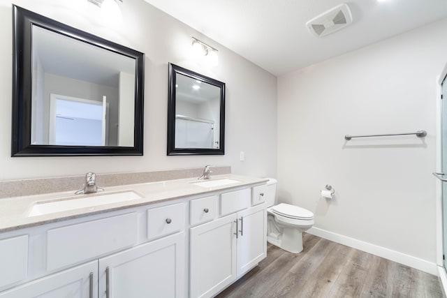 full bath featuring toilet, visible vents, wood finished floors, and a sink