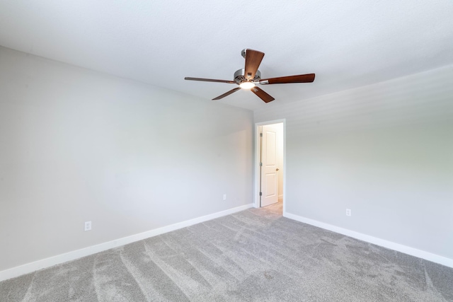 spare room with ceiling fan, carpet, and baseboards