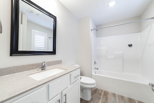 full bathroom with toilet, visible vents, vanity, wood finished floors, and shower / bathing tub combination