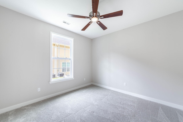 carpeted spare room featuring visible vents, baseboards, and a ceiling fan