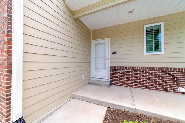 view of exterior entry with brick siding