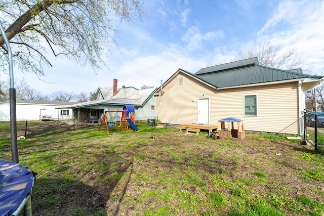 502 Hackberry, Fayette, MO 65248 - rear view of property featuring fence, metal roof, and a playground