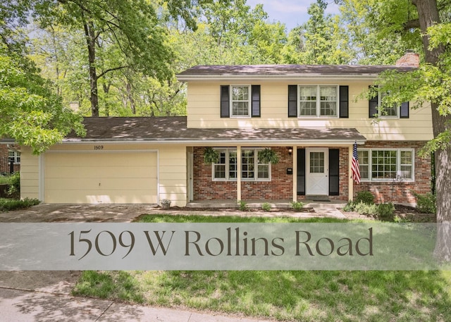 1509 W Rollins Rd, Columbia, MO 65203 - traditional-style home featuring concrete driveway, an attached garage, a chimney, and brick siding