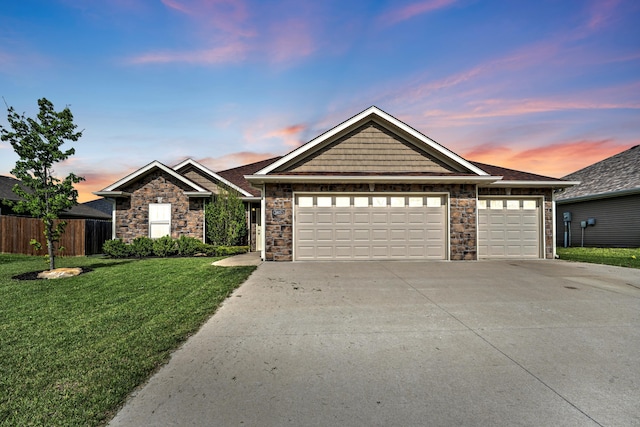 ranch-style home featuring fence, an attached garage, stone siding, a front yard, and driveway