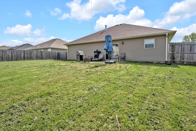 back of property with a patio, a fenced backyard, and a lawn