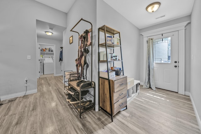 entrance foyer featuring separate washer and dryer, baseboards, light wood finished floors, and visible vents