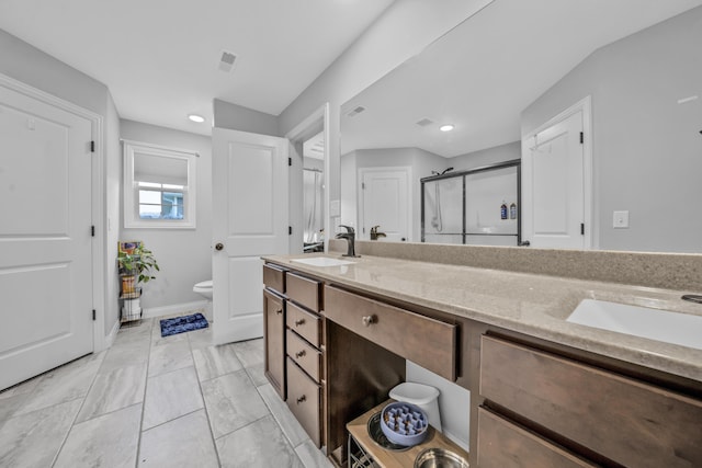 bathroom featuring a sink, double vanity, toilet, recessed lighting, and a shower stall