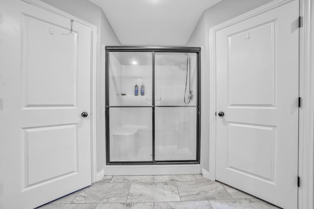 full bath featuring baseboards, marble finish floor, and a stall shower