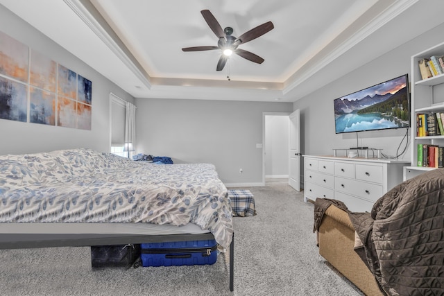 carpeted bedroom with baseboards, ceiling fan, and a tray ceiling