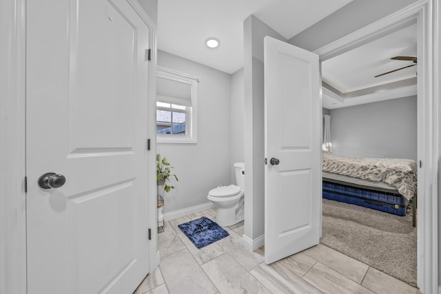 bathroom with connected bathroom, toilet, and baseboards