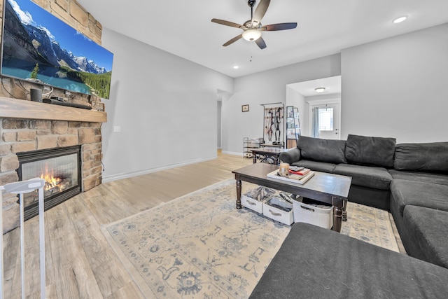 living room featuring ceiling fan, a fireplace, wood finished floors, baseboards, and recessed lighting