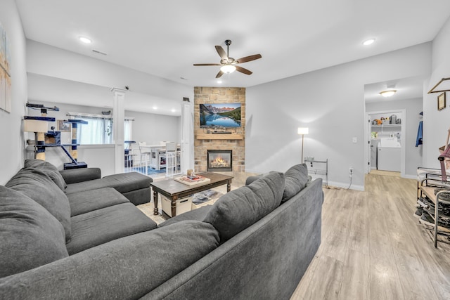 living room featuring a ceiling fan, recessed lighting, a stone fireplace, and light wood finished floors