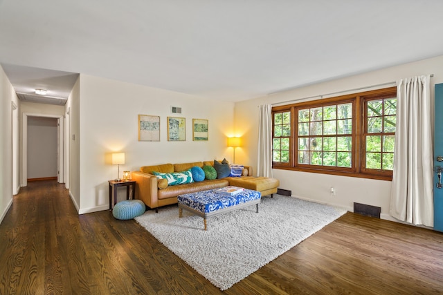 living room featuring baseboards, dark wood finished floors, and visible vents