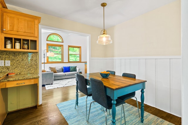 dining room with wainscoting and dark wood-type flooring