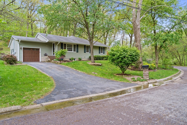 ranch-style house with an attached garage, a front lawn, roof with shingles, and driveway